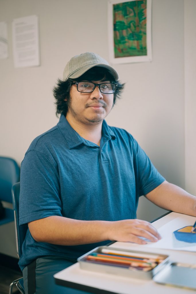 UMO Graphic Design student sitting at desk