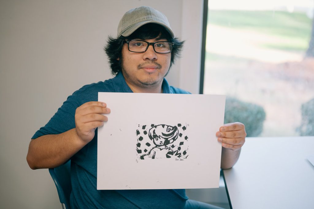 UMO Design student holding up artwork