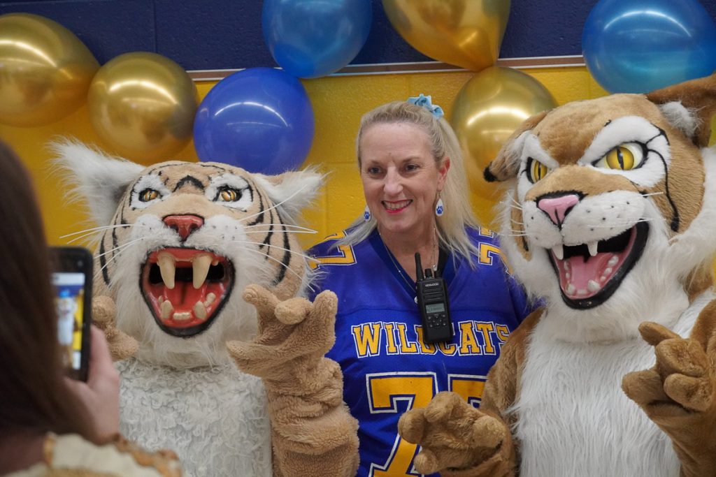 Woman standing with two school mascots