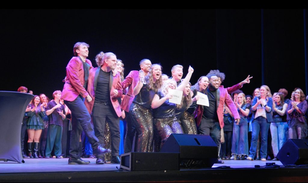 UMO A Cappella group celebrating on stage