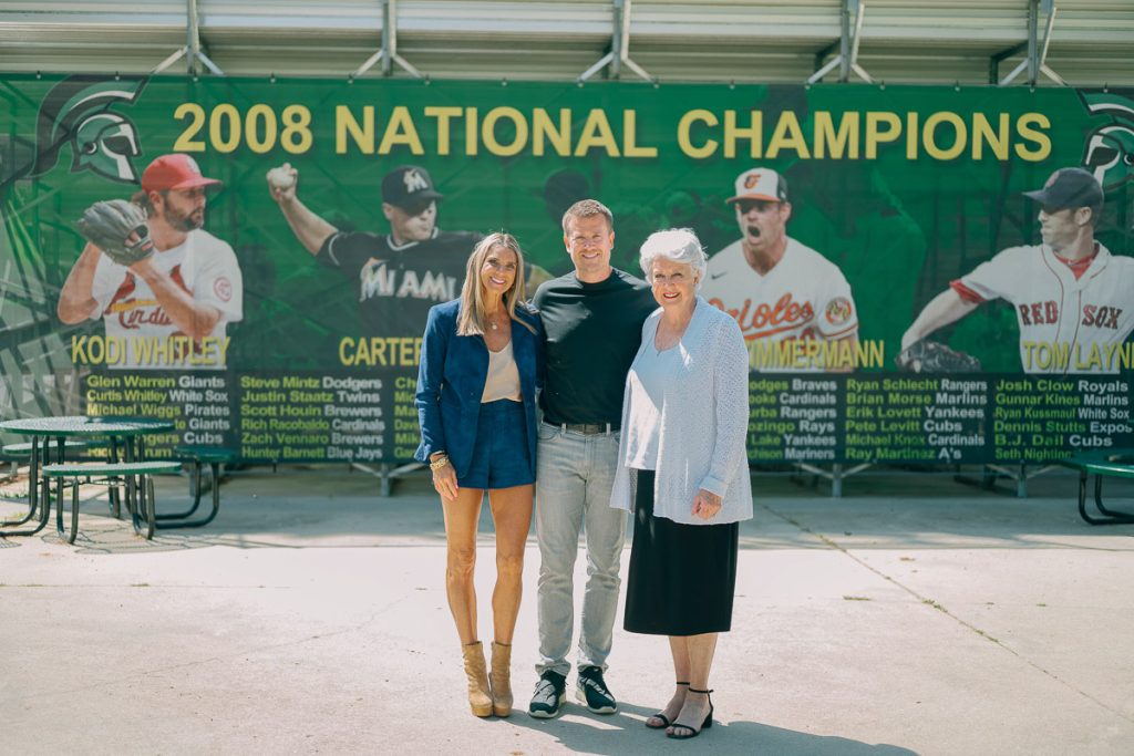 Group of people standing in front of UMO Baseball field.