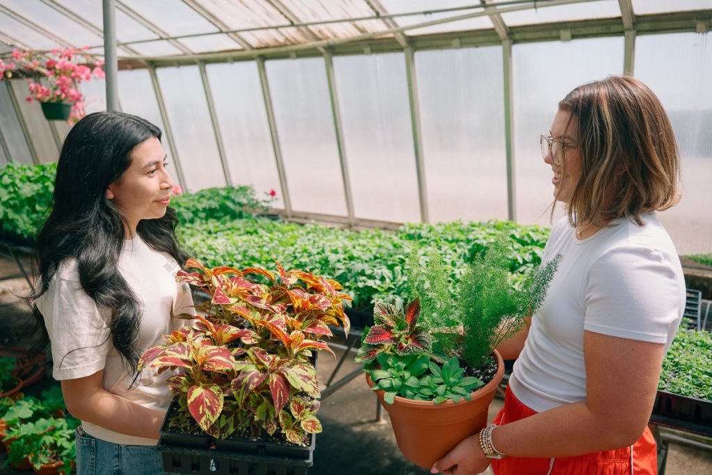 UMO Ag students in greenhouse holding plants