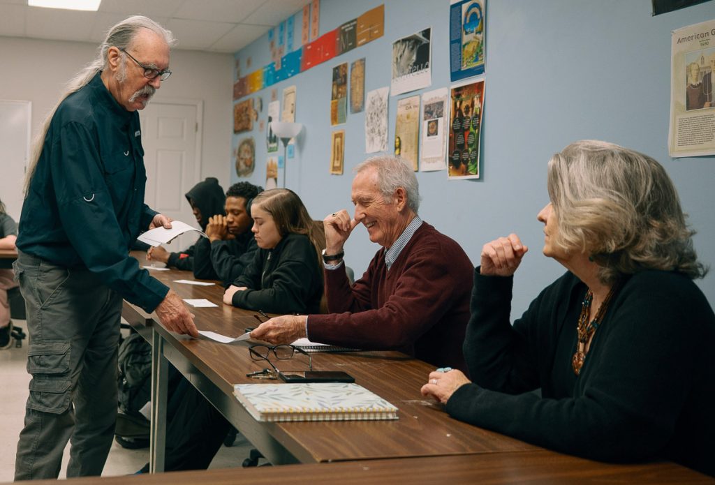 Professor handing out papers in classroom